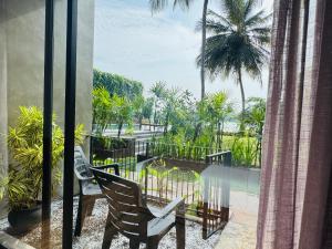 a balcony with a table and chairs and palm trees at New Diyakawa Boutique Hotel in Nikawatawana