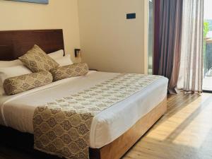 a bedroom with a large bed with a wooden headboard at New Diyakawa Boutique Hotel in Nikawatawana