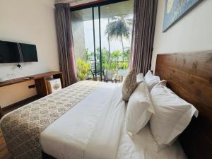 a bedroom with a white bed with a large window at New Diyakawa Boutique Hotel in Nikawatawana