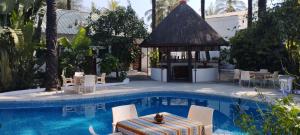 a pool with a gazebo and chairs and a table at BALAFON hôtel in Cap Skirring +17 photos