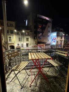 a picnic table and chairs on a balcony at night at Villa Romana in Bucharest