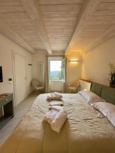 a large bed in a room with towels on it at La Dimora Di Roberta in Montalcino