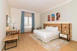 a hotel room with a large bed and a table at Hasanah Suites Serviced Apartment- شقق أجنحة حسنة للشقق المخدومة in Medina +66 photos