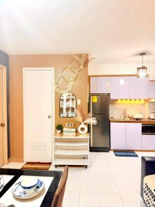 a kitchen with a refrigerator and a table at Relaxing 2BR at Camella Northpoint with balcony pool view 3rd floor in Davao City