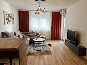a living room with a couch and a tv at Union Apartment in Ferizaj