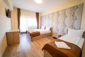 ein Hotelzimmer mit zwei Betten und einem Fenster in der Unterkunft Urusossziklakert in Dealu
