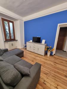 a living room with a couch and a blue wall at sunflower apartment in Domaso