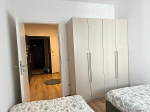 a bedroom with a bed and a white cabinet at Union Apartment in Ferizaj