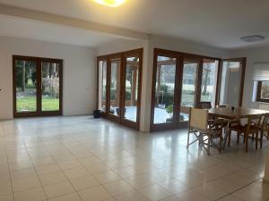 a dining room with a table and chairs and sliding glass doors at Dom pod lesom v Borinke in Stupava