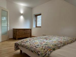 a bedroom with a bed and a dresser and a window at Dom pod lesom v Borinke in Stupava