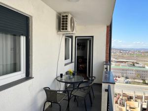 a balcony with a table and chairs and a window at Union Apartment in Ferizaj
