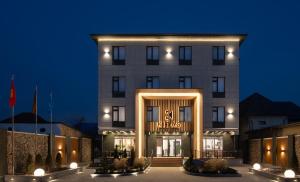 a hotel with a lit up facade at night at Kibas Hotel in Bishkek