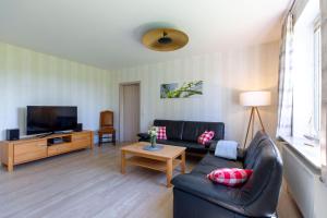 a living room with a couch and a tv at Hus-Pellworm-1-Ferienwohnung-Meerestraum in Pellworm