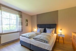 a bedroom with a bed with white pillows and a window at Hus-Pellworm-1-Ferienwohnung-Meerestraum in Pellworm