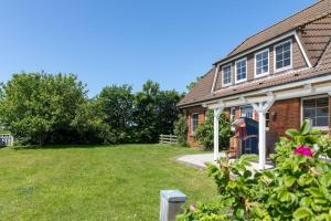 a house with a yard in front of it at Hus-Pellworm-1-Ferienwohnung-Meerestraum in Pellworm +27 photos