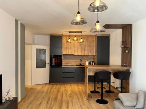a kitchen with a wooden counter and black cabinets at Union Apartment in Ferizaj