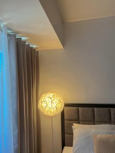 a lamp in a bedroom next to a bed at La Montañosa at Brenthill Baguio Condo near City Center in Baguio +57 photos