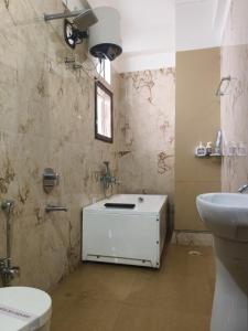 ein Badezimmer mit einem weißen Waschbecken und einer Toilette in der Unterkunft Hotel Hempi in Diphu + 15 Fotos