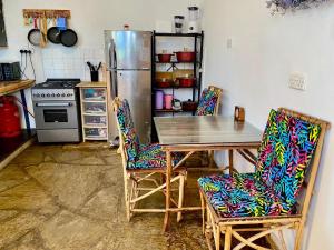 a kitchen with a table and chairs and a refrigerator at HIGSAM apartment in Ukunda