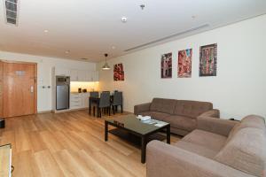 a living room with a couch and a table at Hasanah Suites Serviced Apartment- شقق أجنحة حسنة للشقق المخدومة in Medina