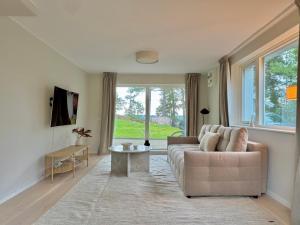 a living room with a couch and a table at Modern Seaside Guesthouse with Archipelago Views in Nacka