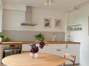 a kitchen with a table and a vase with purple flowers at Modern Seaside Guesthouse with Archipelago Views in Nacka