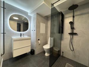 a bathroom with a toilet and a sink and a shower at Modern Seaside Guesthouse with Archipelago Views in Nacka +66 photos