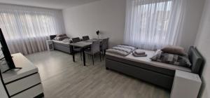 a room with two beds and a dining room with a table at Boxspring Apartment Rottweil mit Stellplatz in Rottweil