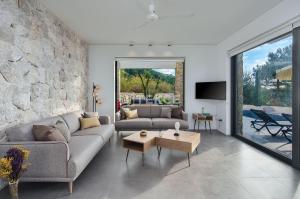 a living room with a stone wall at TEKCE Villa Faralya N131 in Kızılcakaya