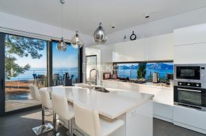 a kitchen with white appliances and a view of the ocean at TEKCE Villa Faralya N131 in Kızılcakaya
