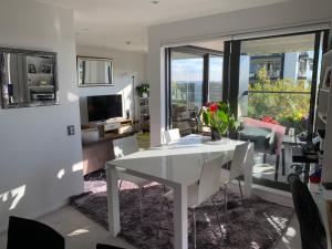 a living room with a white dining room table at Urba Residences in Auckland