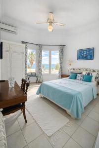 a bedroom with a bed and a desk and windows at Hotel Plaza la marsa in Tunis