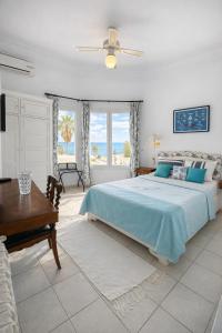 a bedroom with a bed and a desk and windows at Hotel Plaza la marsa in Tunis