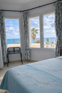 a bedroom with a bed and a view of the beach at Hotel Plaza la marsa in Tunis
