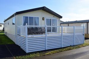 a mobile home with a porch and a deck at Shrimp Shack in Heysham