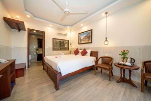 a hotel room with a bed and a desk and a sink at Bonsai Villa Hoi An in Hoi An