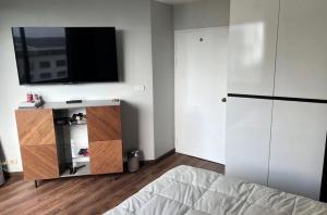 a bedroom with a bed and a flat screen tv on the wall at Suvannee guesthouse in Ban Khlong Hua Sakae