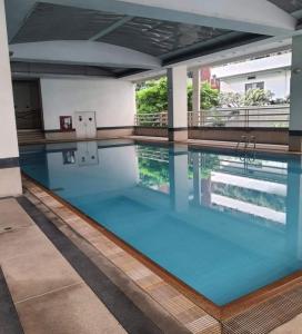 a swimming pool with blue water in a building at Suvannee guesthouse in Ban Khlong Hua Sakae