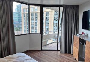 a bedroom with a bed and a large window at Suvannee guesthouse in Ban Khlong Hua Sakae