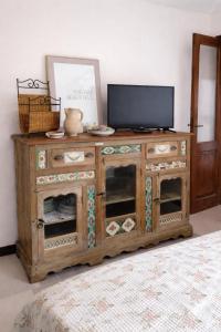 a wooden entertainment center with a television on top at Casa Rosa - monolocale con giardino e posto auto in Levanto