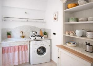 a kitchen with a washing machine and a sink at Casa Rosa - monolocale con giardino e posto auto in Levanto