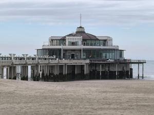 a large building on the beach next to the ocean at Villa vague bleue Blankenberge in Blankenberge
