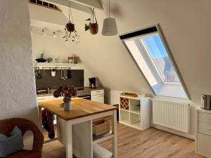 an attic kitchen with a table and a window at Ferienwohnung Storchennest Vipperow in Ludorf