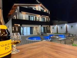 a bottle of wine sitting on a table in front of a house at Davos Hotel in Pʼarakʼar