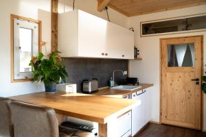 a kitchen with white cabinets and a wooden table at Modernes Tiny Haus in Berlin Spandau in Berlin