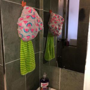 a bathroom with two towels on the wall and a mirror at Thesh Home at Tsavo Sunset 2 ,Thindigua Kiambu Road in Kiambu +18 photos