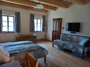 a living room with two beds and a flat screen tv at Lotrinský Apartmány in Hodruša