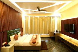 a bedroom with a bed and a desk and a television at Tulsi Resort in Gorakhpur