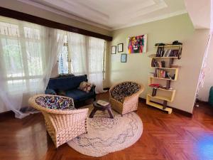 a living room with two chairs and a couch at Giving Hands Homestay in Arusha