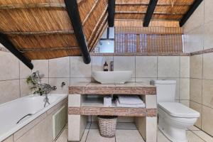 a bathroom with a sink and a tub and a toilet at Jewel On Juweel in Four Ways +27 photos